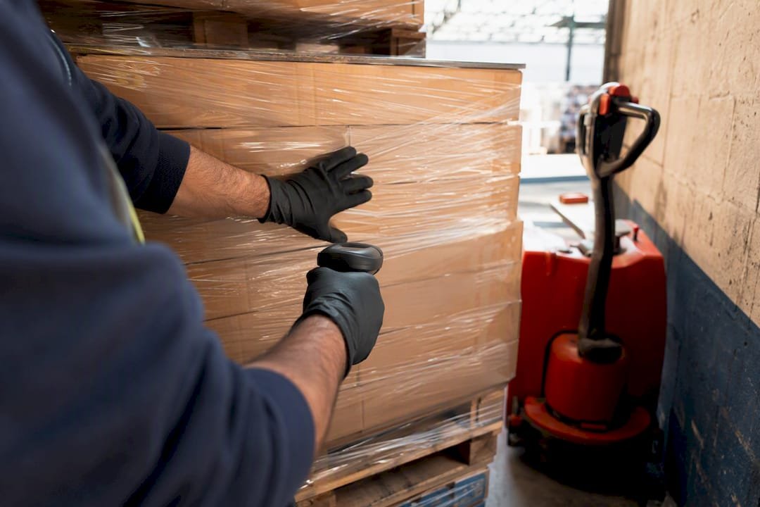 Worker inspecting pallet at dock